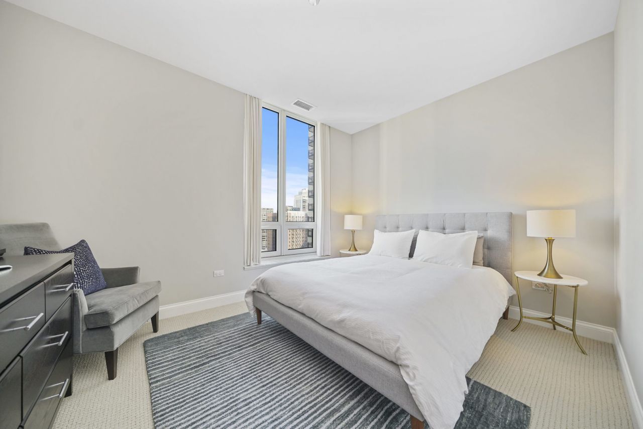 10 East Delaware Place, Unit 18E Chicago, IL 60611 - Photo 27 of 56 a bedroom with a bed and a window