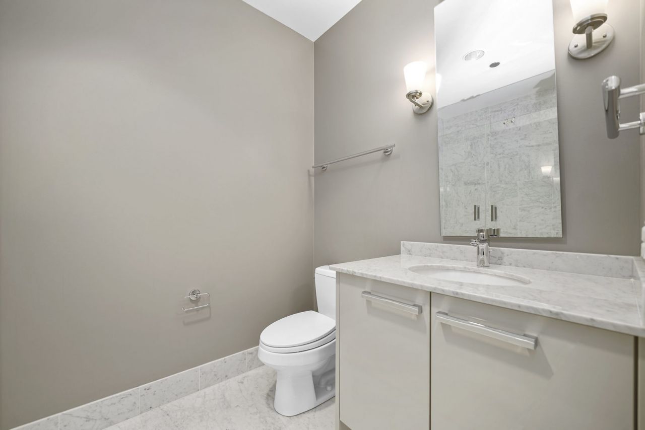 10 East Delaware Place, Unit 18E Chicago, IL 60611 - Photo 28 of 56 a bathroom with a sink a toilet and a mirror