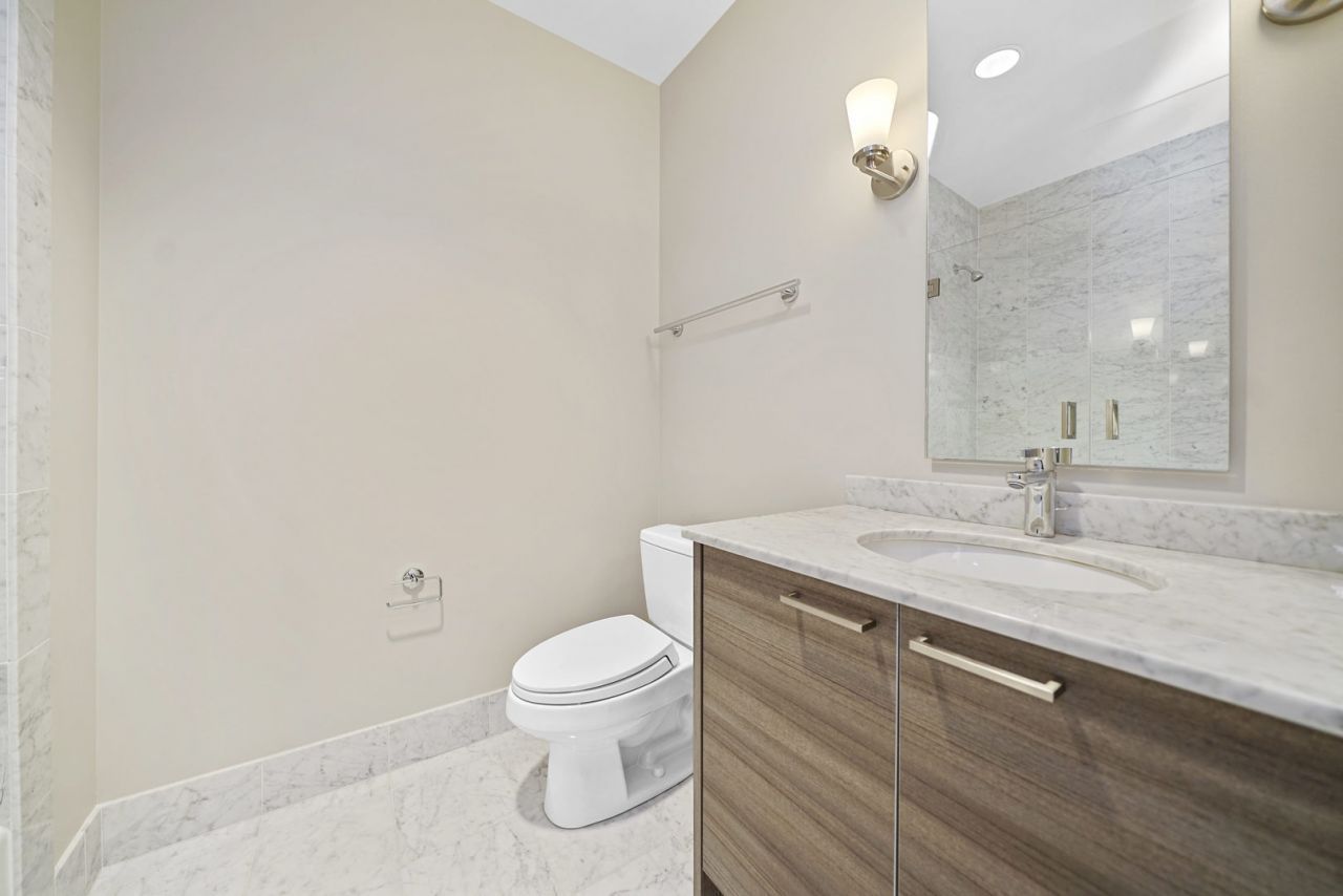 10 East Delaware Place, Unit 18E Chicago, IL 60611 - Photo 32 of 56 a bathroom with a granite countertop sink a toilet and a mirror
