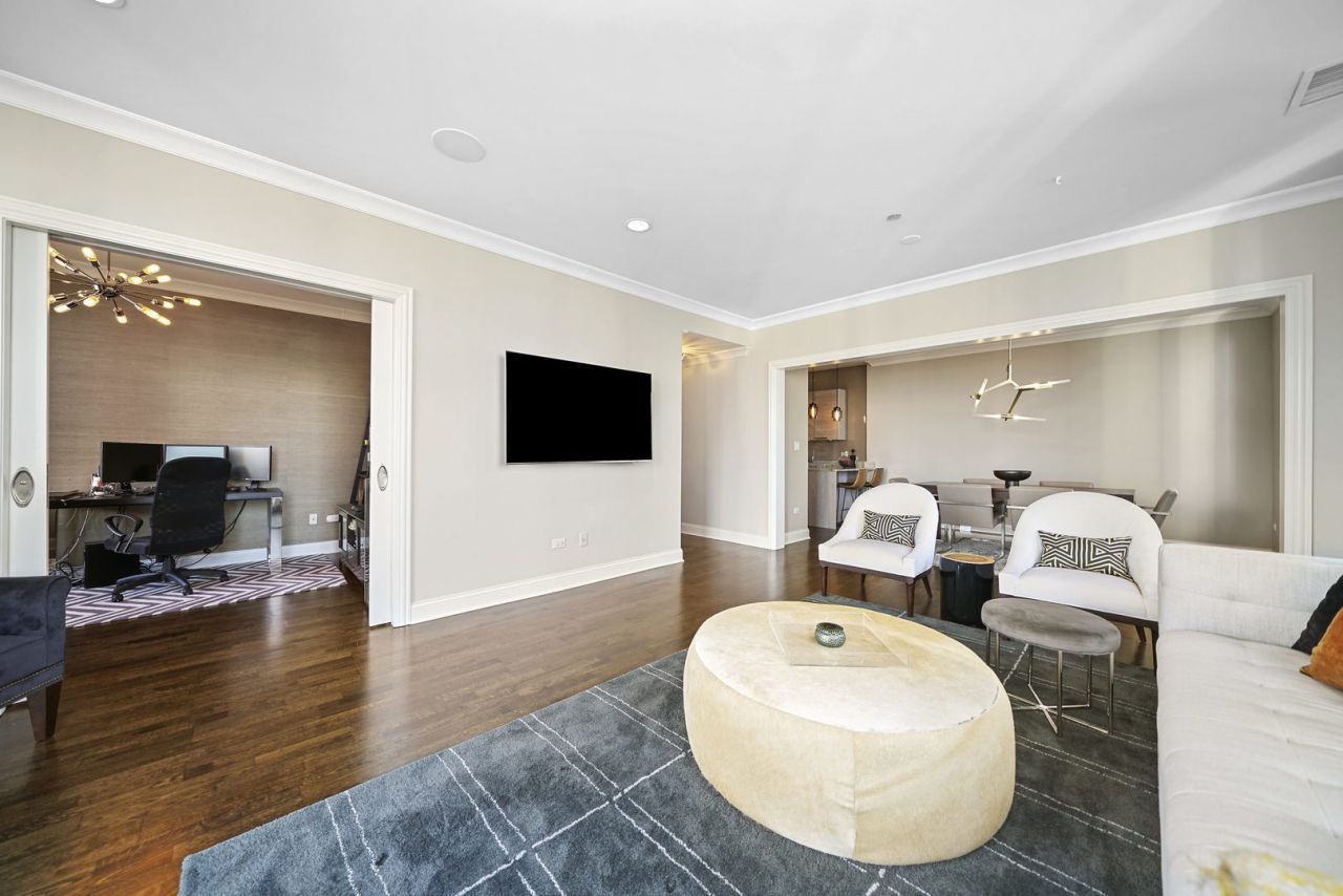 10 East Delaware Place, Unit 18E Chicago, IL 60611 - Photo 7 of 56 a living room with couches and a flat screen tv