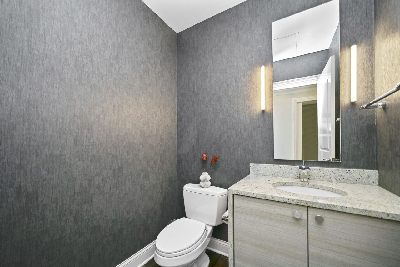10 East Delaware Place, Unit 18E Chicago, IL 60611 - Photo 9 of 56 a bathroom with a granite countertop sink toilet and a mirror