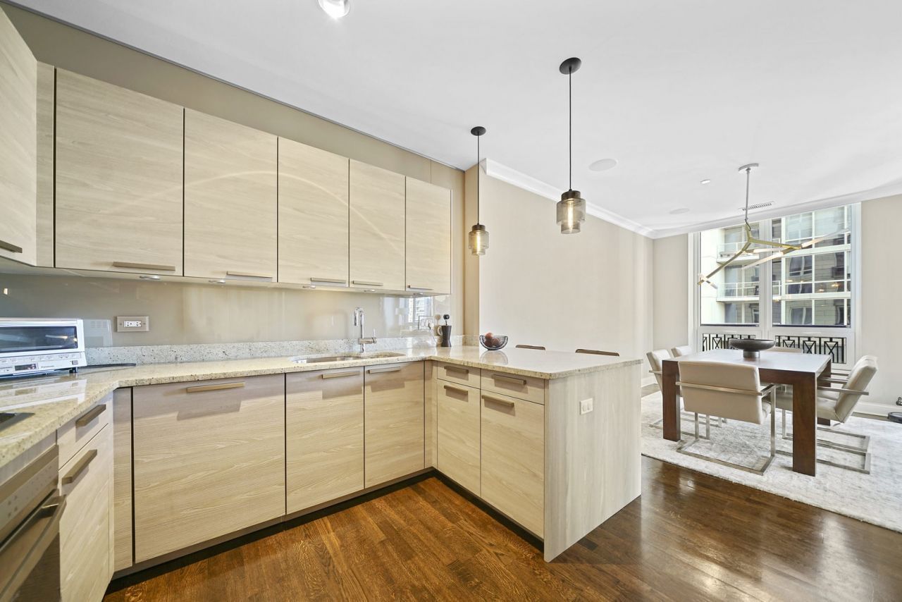10 East Delaware Place, Unit 18E Chicago, IL 60611 - Photo 10 of 56 a kitchen with a stove a sink a dining table and chairs