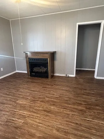 a view of empty room with wooden floor and fireplace