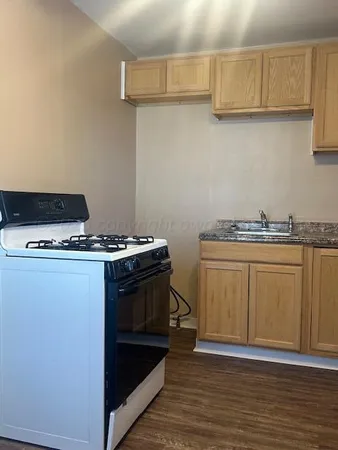 a kitchen with granite countertop a stove and a sink
