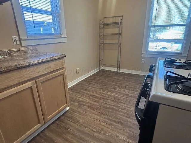 a view of a kitchen with fridge and wooden floor