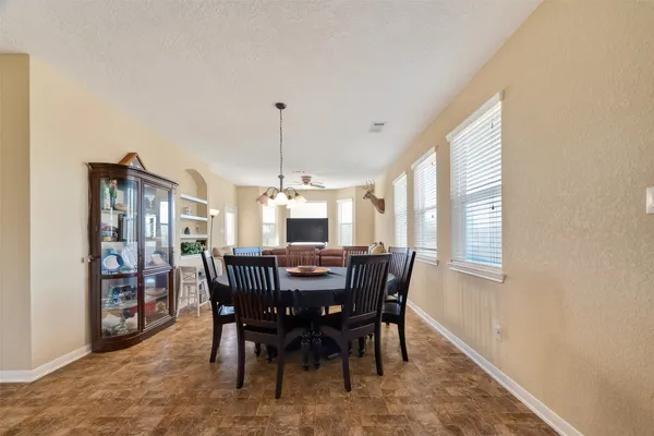 a kitchen with stainless steel appliances granite countertop a table chairs sink and cabinets