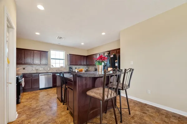 a kitchen with granite countertop a sink stove and cabinets