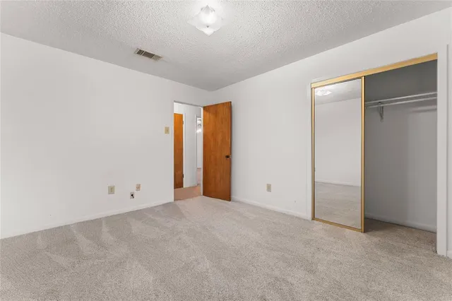 an empty room with an entryway and closet