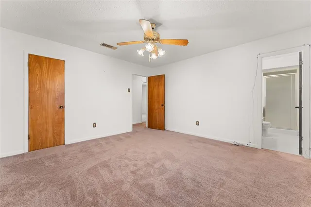 a view of an empty room with a ceiling fan