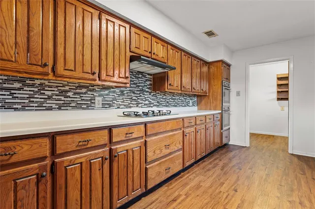 a kitchen with stainless steel appliances granite countertop cabinets and wooden floor
