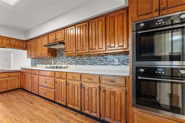 a kitchen with stainless steel appliances granite countertop a stove a sink and a microwave