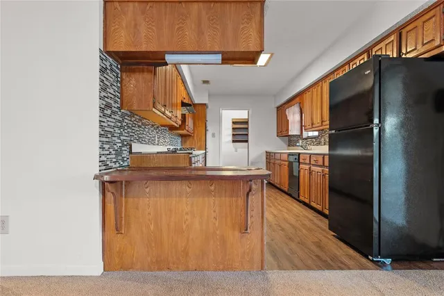 a kitchen with stainless steel appliances a refrigerator and a stove top oven