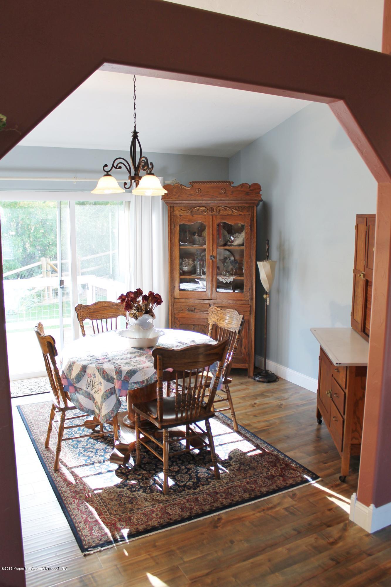 695 Birch Court Rifle, CO 81650 - Photo 23 of 46 a dining room with wooden floor a chandelier a wooden table and chairs