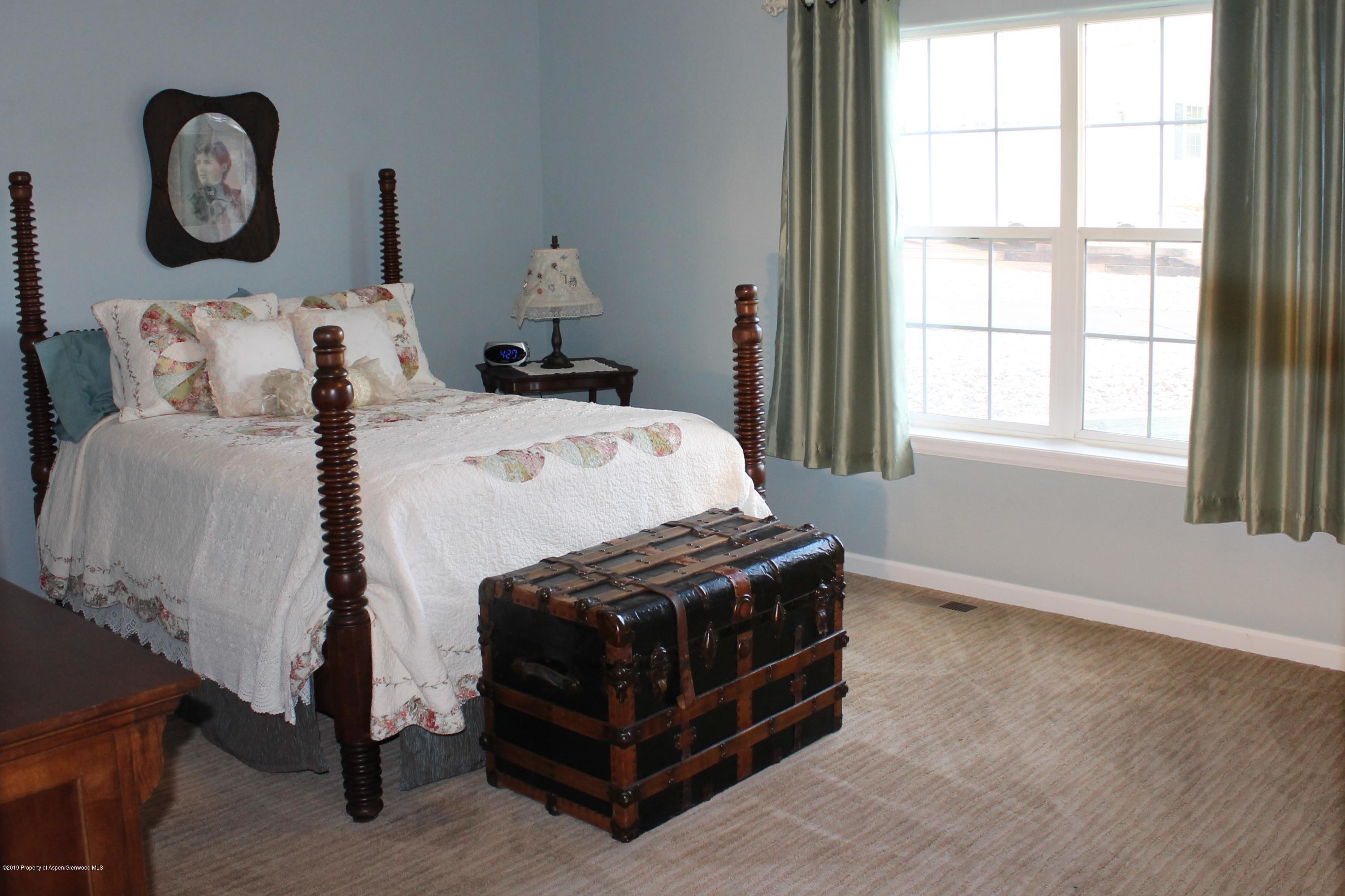 695 Birch Court Rifle, CO 81650 - Photo 9 of 46 a bed sitting in a bedroom next to a window