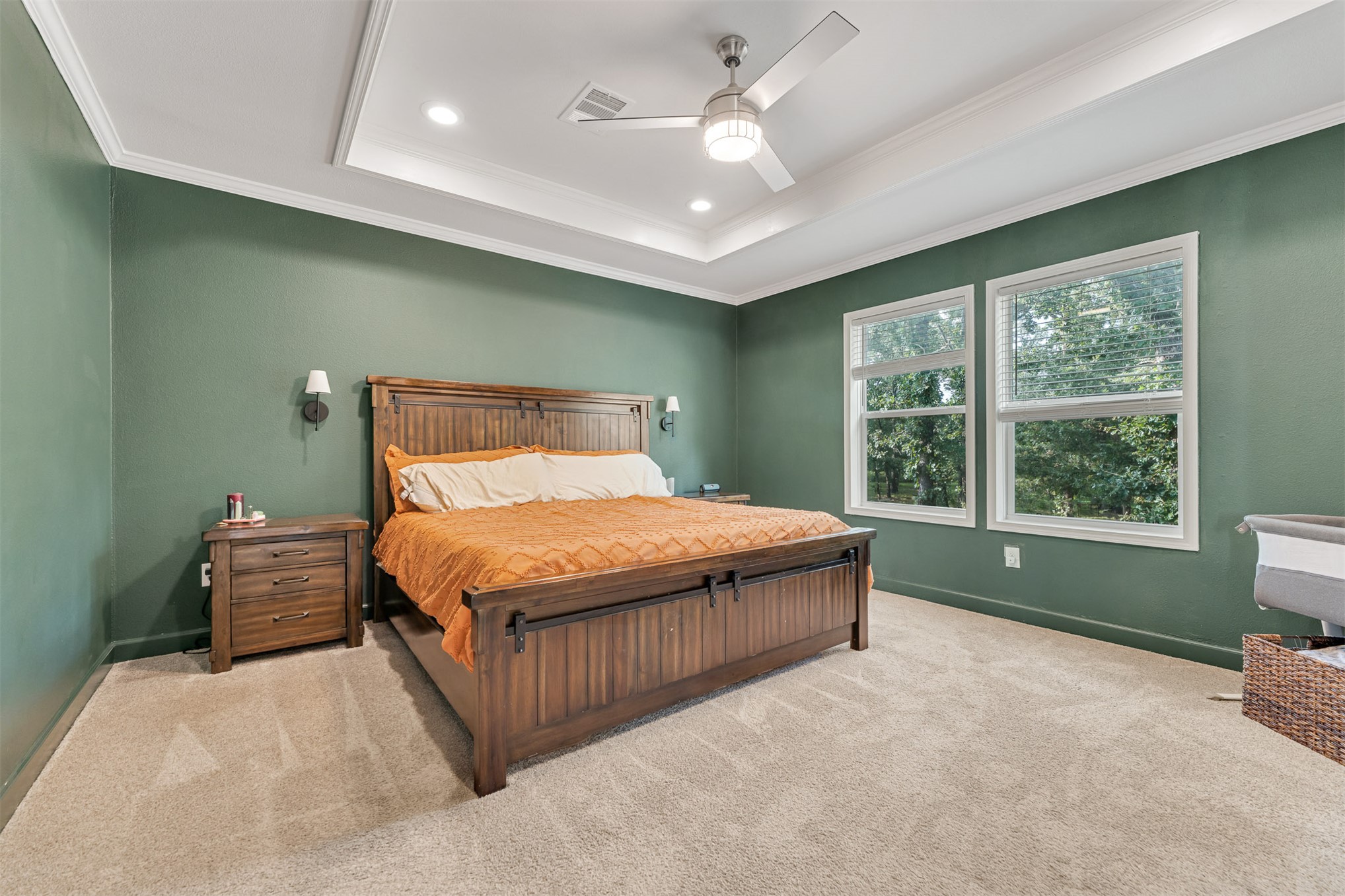 15291 East 400 Road Claremore, OK 74017 - Photo 29 of 96 Tray ceiling with recessed lighting, ceiling fan with integrated light, dual windows, wall-mounted sconces, and crown molding
