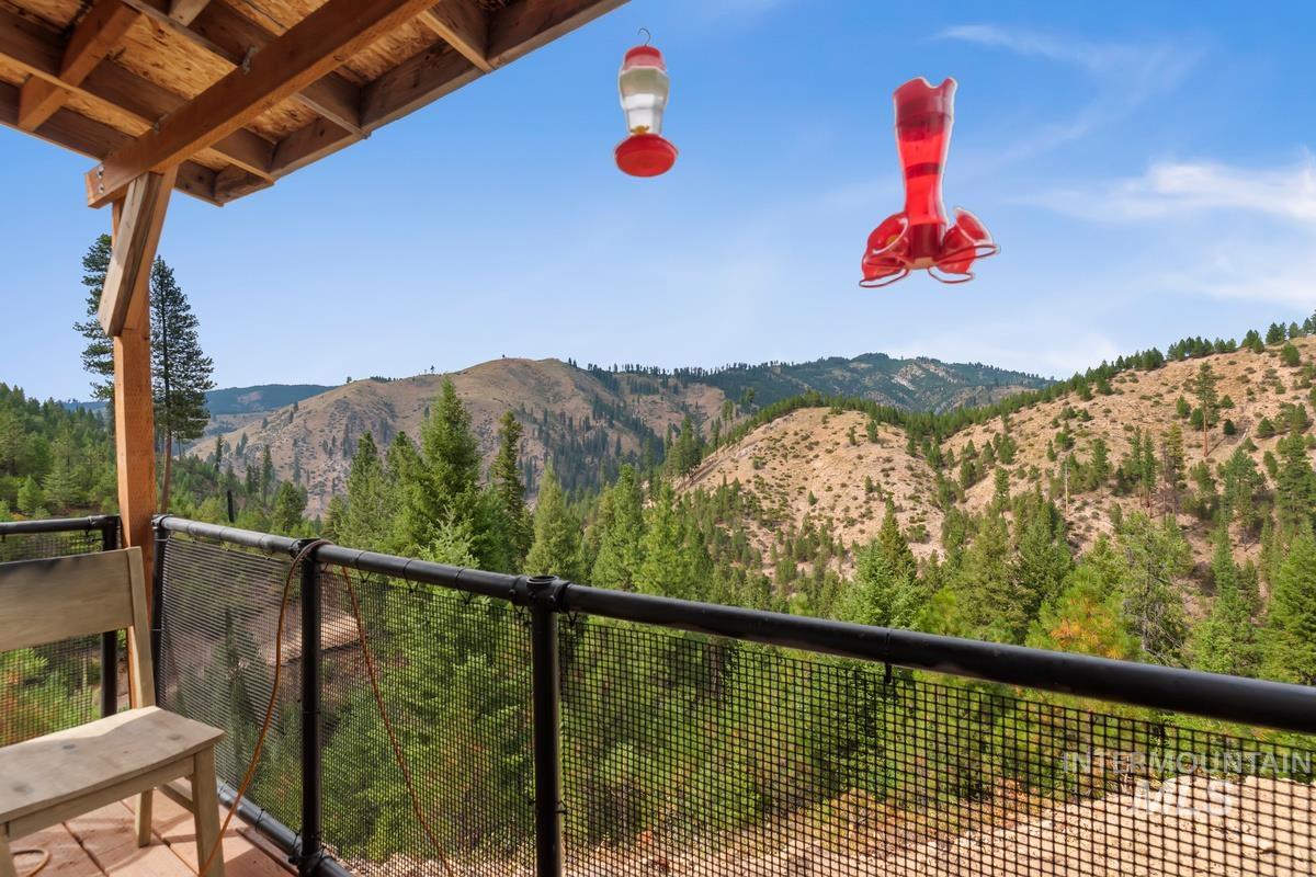 7 Scenic Rim Circle Lowman, ID 83637 - Photo 11 of 35 Outdoor deck featuring a wood post and beam overhead structure, black metal railings, and a wire mesh guard