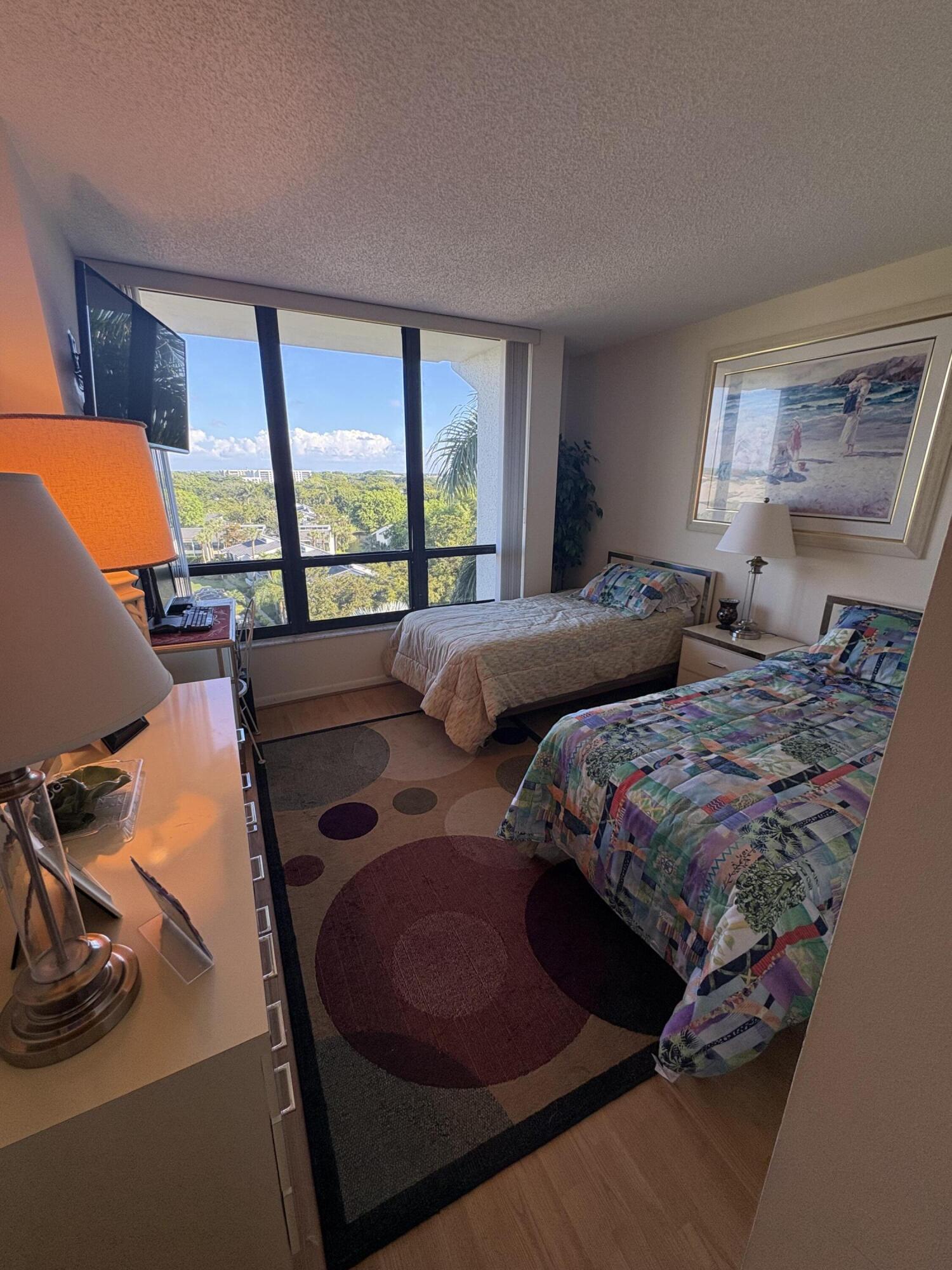 6895 Willow Wood Drive, Unit 1083 Boca Raton, FL 33434 - Photo 14 of 56 a bedroom with a bed and glass window