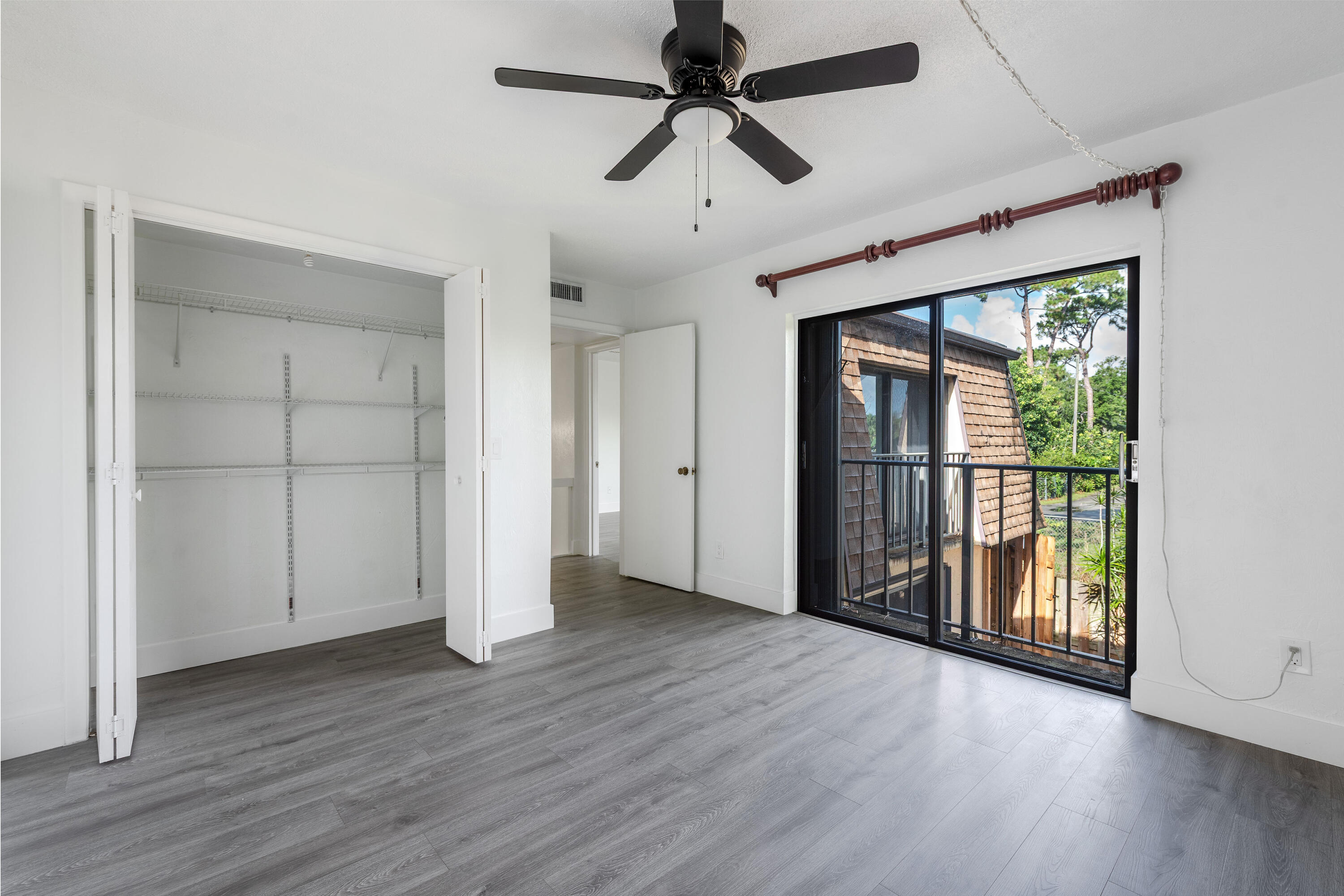 471 Kirk Road, Unit D West Palm Beach, FL 33406 - Photo 14 of 28 a view of empty room with wooden floor and fan