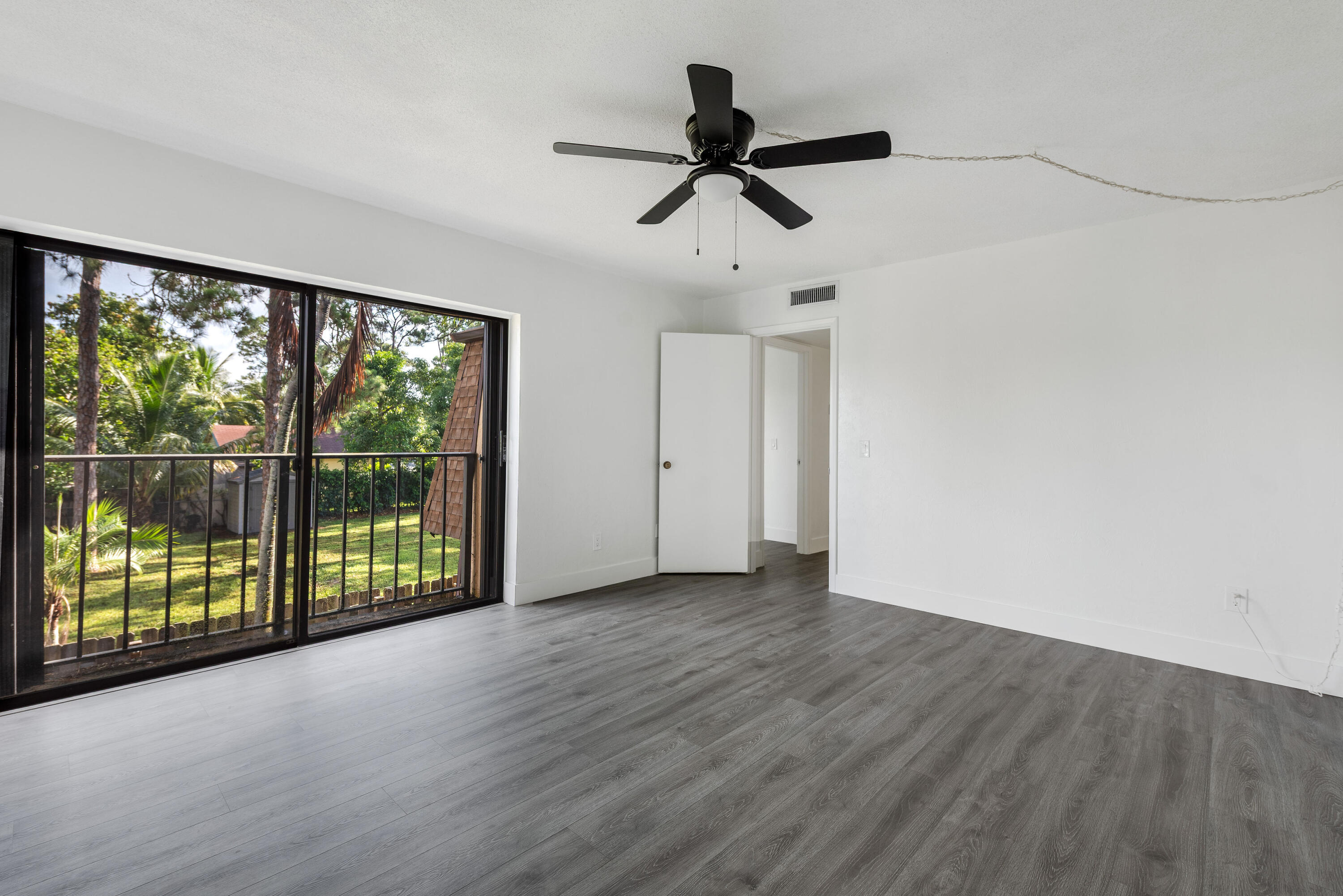 471 Kirk Road, Unit D West Palm Beach, FL 33406 - Photo 18 of 28 a view of empty room with wooden floor and fan