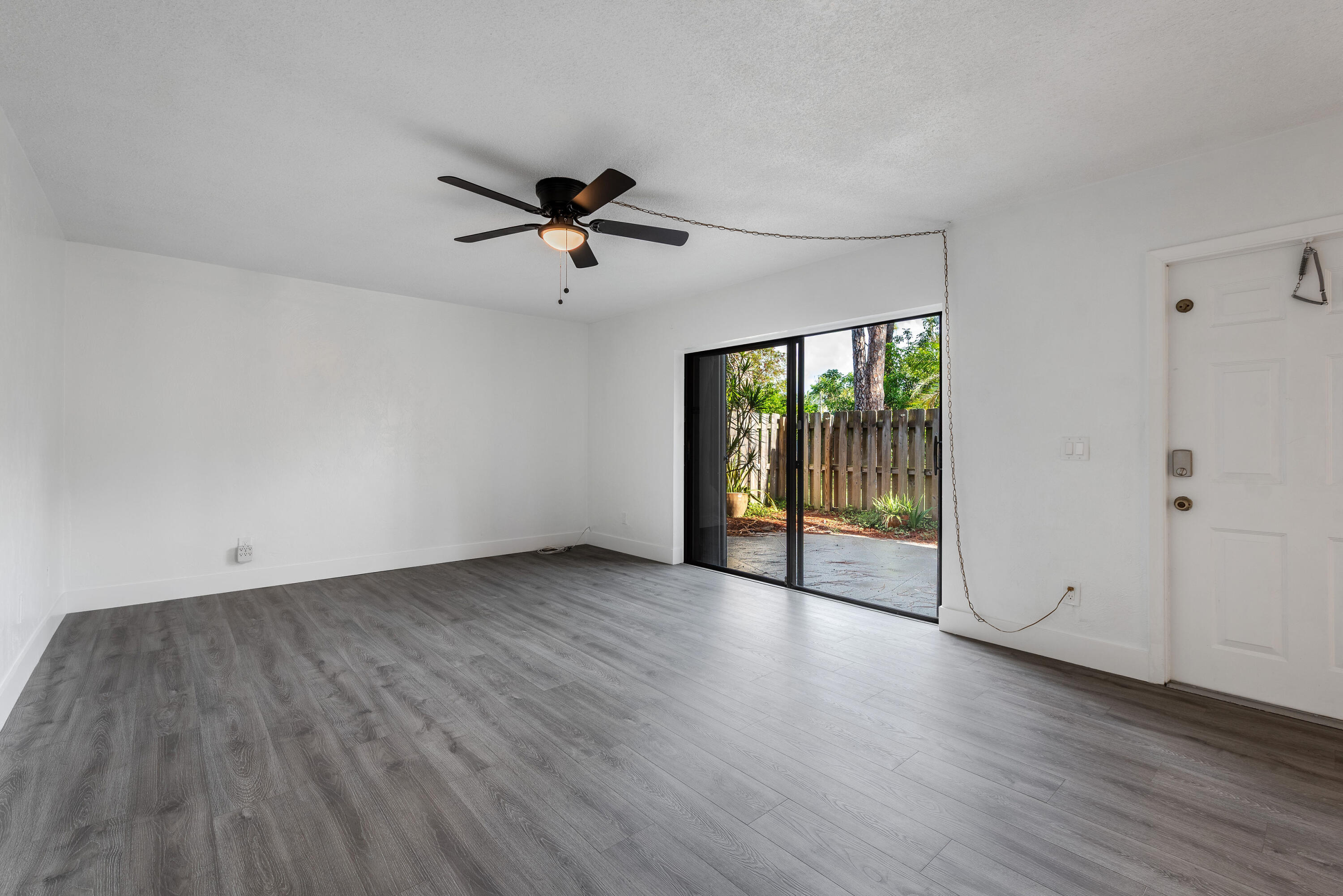 471 Kirk Road, Unit D West Palm Beach, FL 33406 - Photo 4 of 28 wooden floor in an empty room with a window