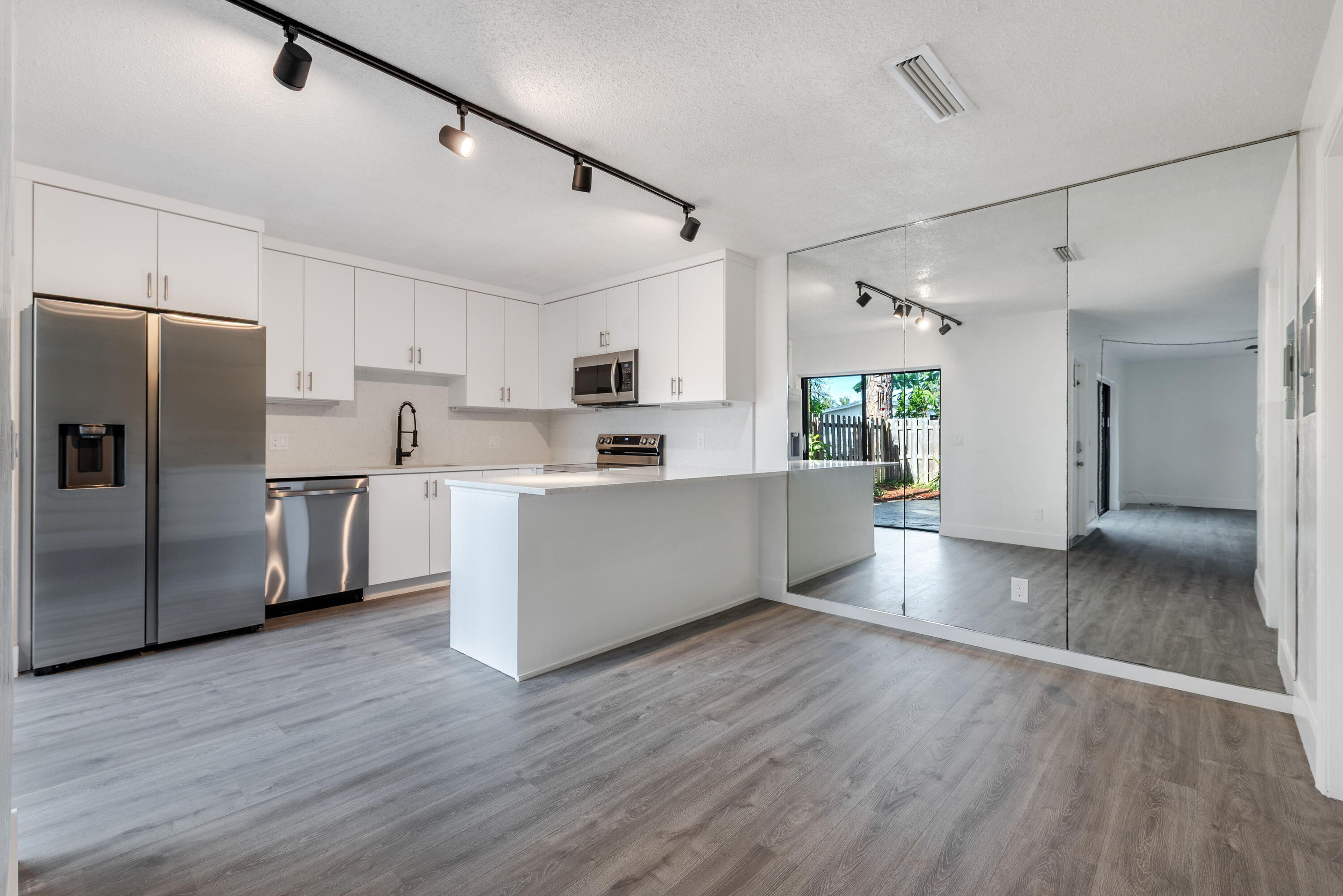471 Kirk Road, Unit D West Palm Beach, FL 33406 - Photo 6 of 28 a kitchen with stainless steel appliances a refrigerator sink and cabinets