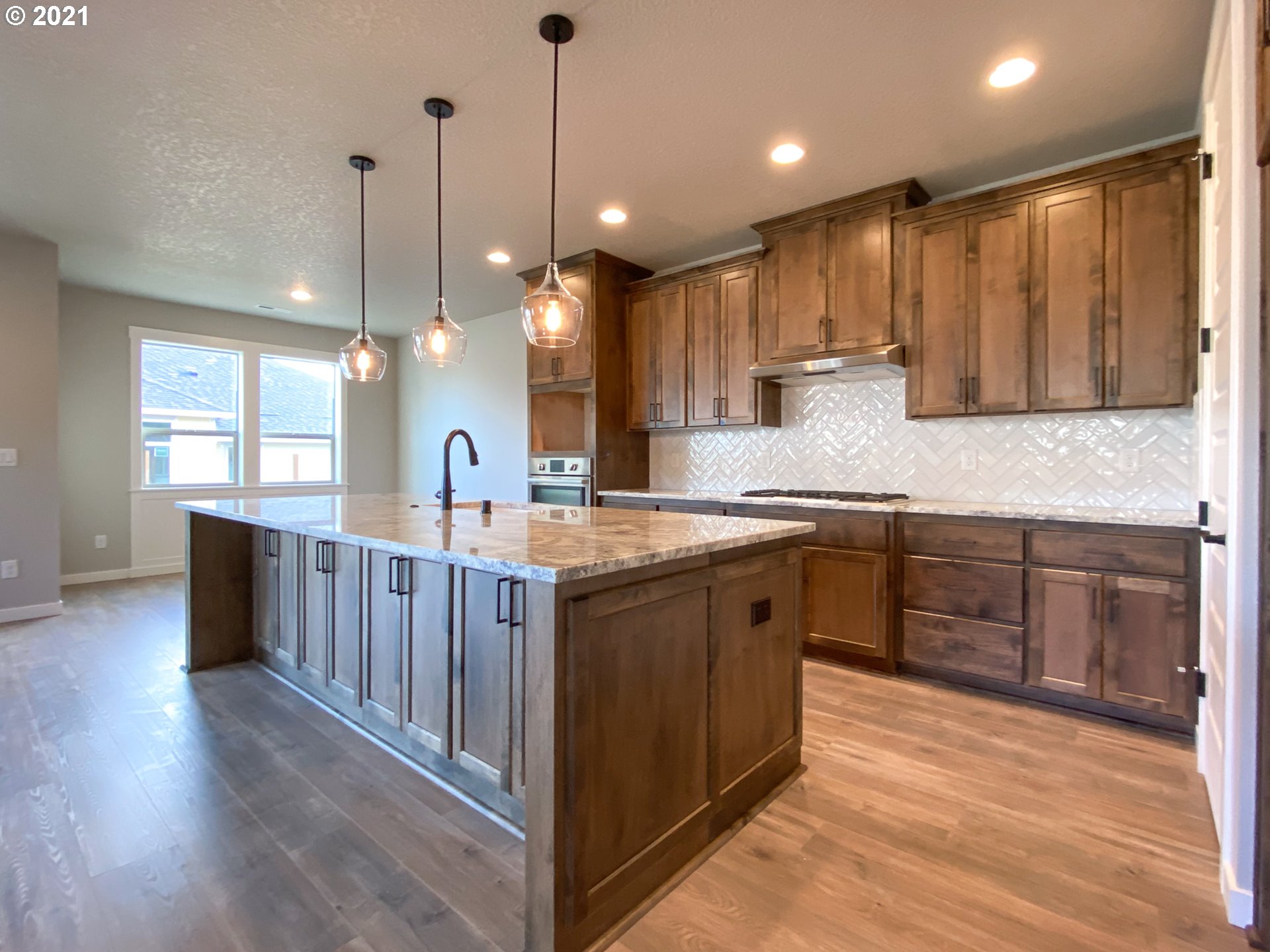 814 South Goose Loop Ridgefield, WA 98642 - Photo 4 of 22 a large kitchen with kitchen island granite countertop a large center island and a wooden floor