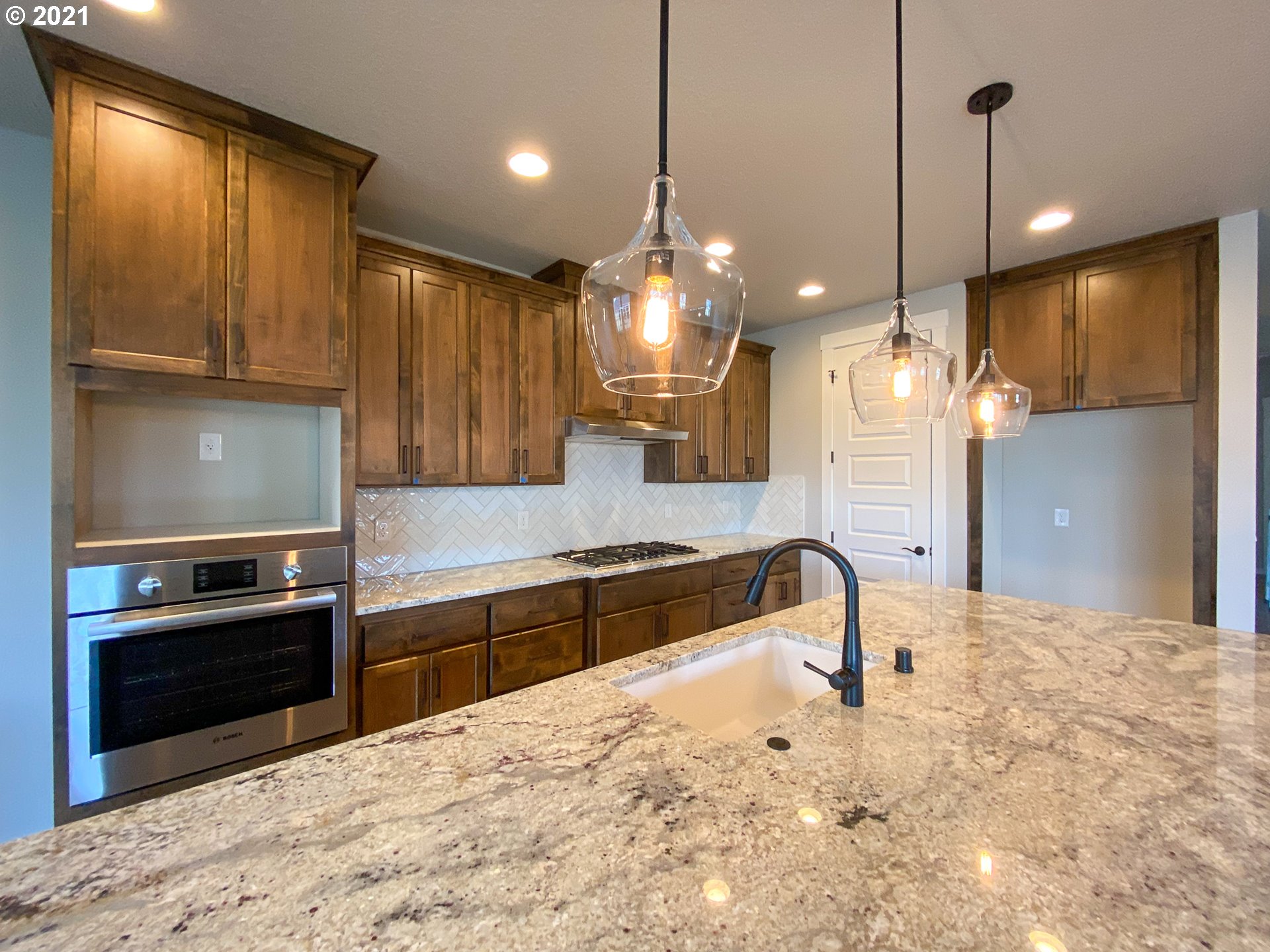814 South Goose Loop Ridgefield, WA 98642 - Photo 5 of 22 a large kitchen with kitchen island granite countertop a sink and a stove