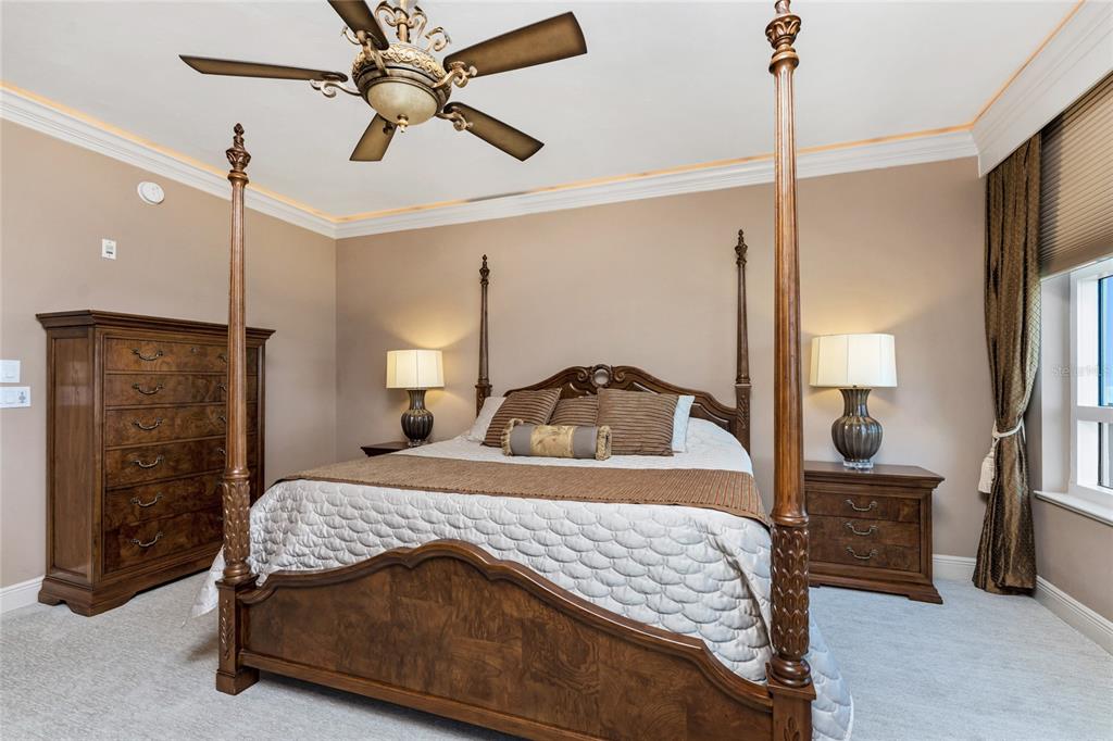 3333 Sunset Key Circle, Unit 506 Punta Gorda, FL 33955 - Photo 21 of 78 a bedroom with a bed a chandelier and a flat tv