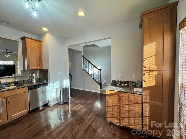 a view of a kitchen with furniture and wooden floor