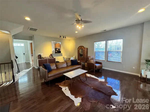 a living room with furniture and a wooden floor