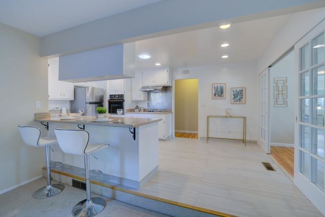 a living room with furniture and kitchen view