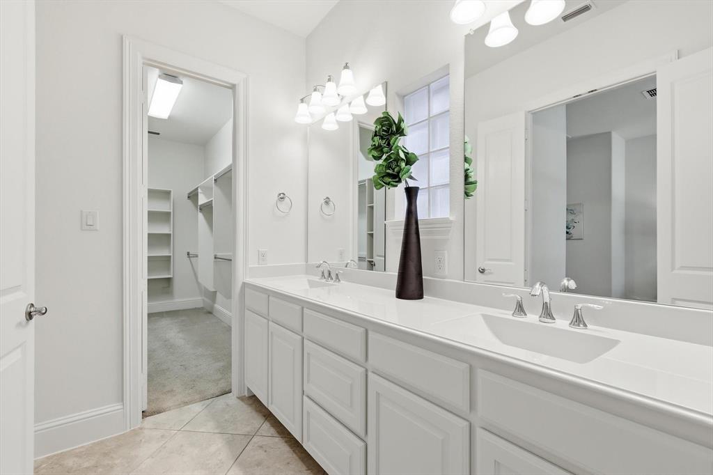 516 Sandy Lane Flower Mound, TX 75022 - Photo 19 of 38 Bathroom featuring a double vanity with two rectangular undermount sinks, chrome faucets, and white cabinetry
