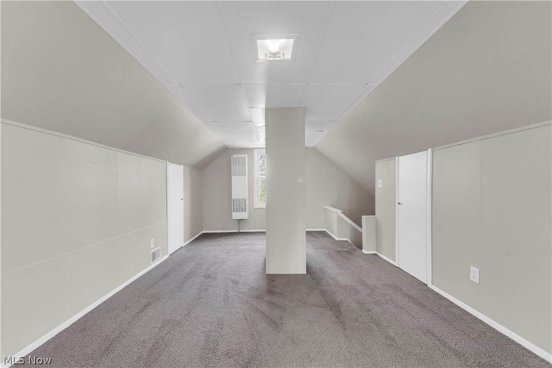 18123 McCracken Road Maple Heights, OH 44137 - Photo 21 of 27 Carpeted room featuring sloped ceilings, white panel walls, and a window
