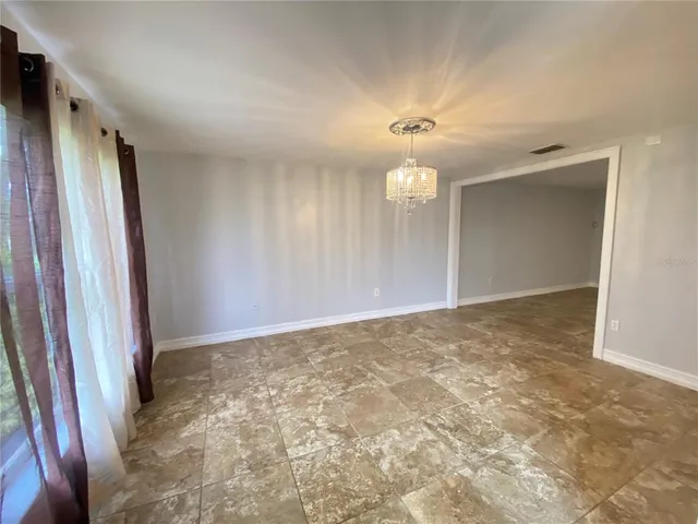 a view of a livingroom with an empty space and a kitchen