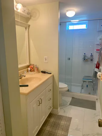 a bathroom with a granite countertop sink a toilet and shower