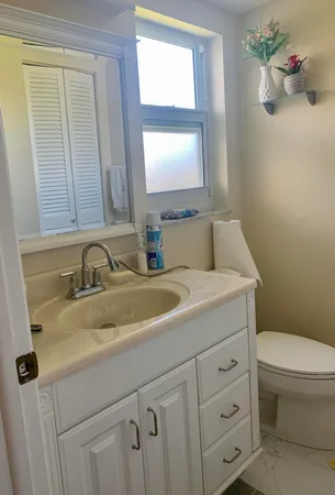 a bathroom with a toilet sink and mirror