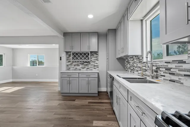 a kitchen with stainless steel appliances granite countertop a sink stove and cabinets