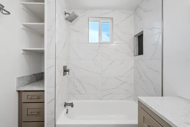 a bathroom with a granite countertop sink a toilet and bathtub