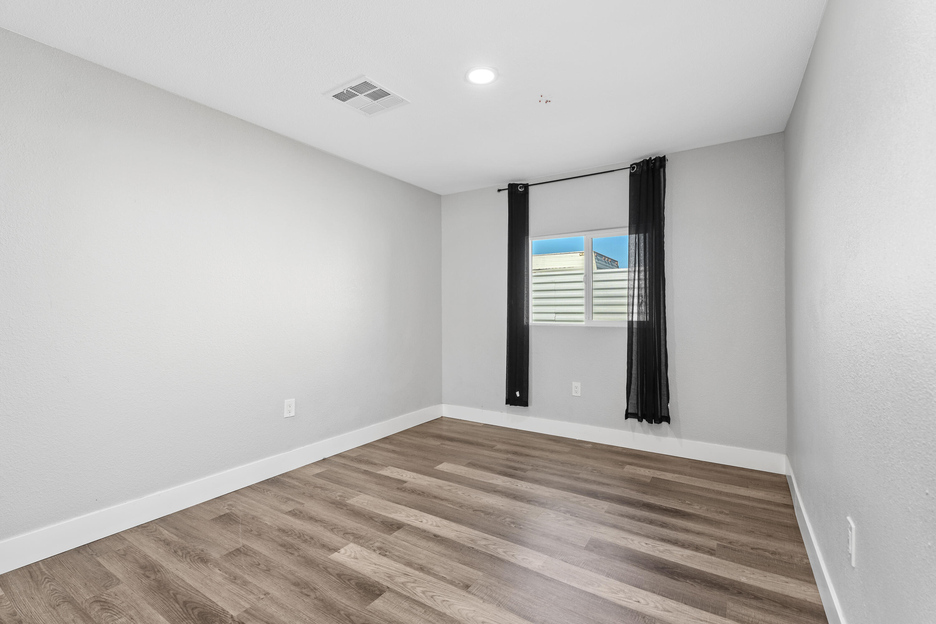 71362 Aurora Road Desert Hot Springs, CA 92241 - Photo 28 of 38 a view of an empty room with wooden floor and a window