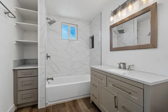 a bathroom with a tub sink and mirror
