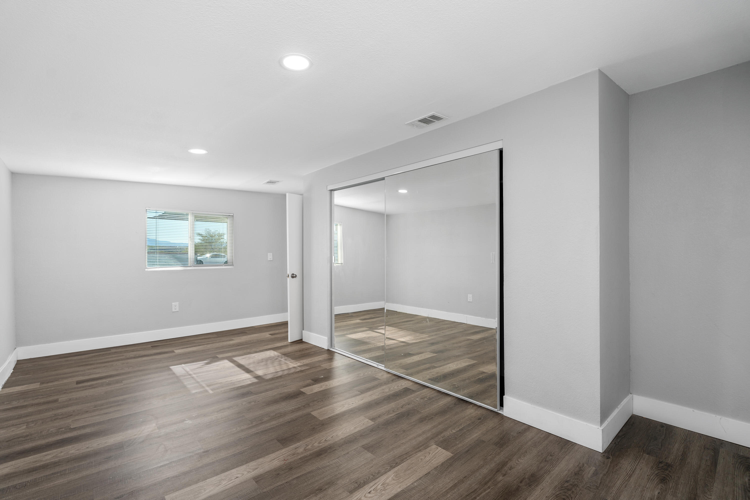 71362 Aurora Road Desert Hot Springs, CA 92241 - Photo 31 of 38 an empty room with wooden floor and windows