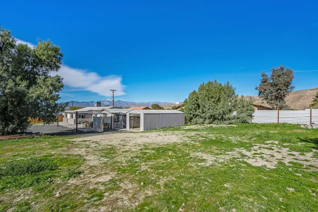 a big white house with a big yard and large trees