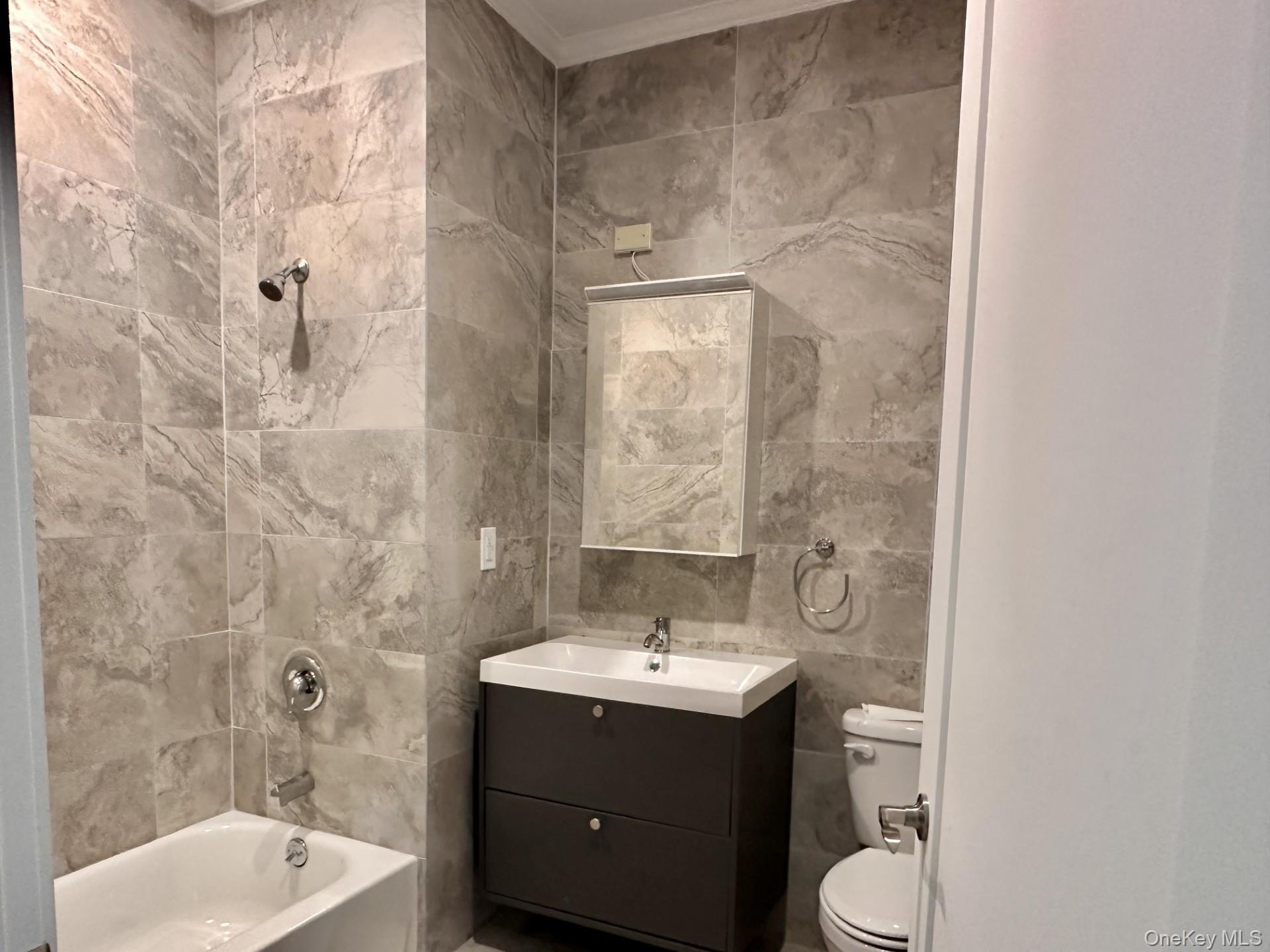 362 West Merrick Road, Unit 106 Valley Stream, NY 11580 - Photo 3 of 6 Full bath featuring tile walls, vanity, and shower / bathtub combination