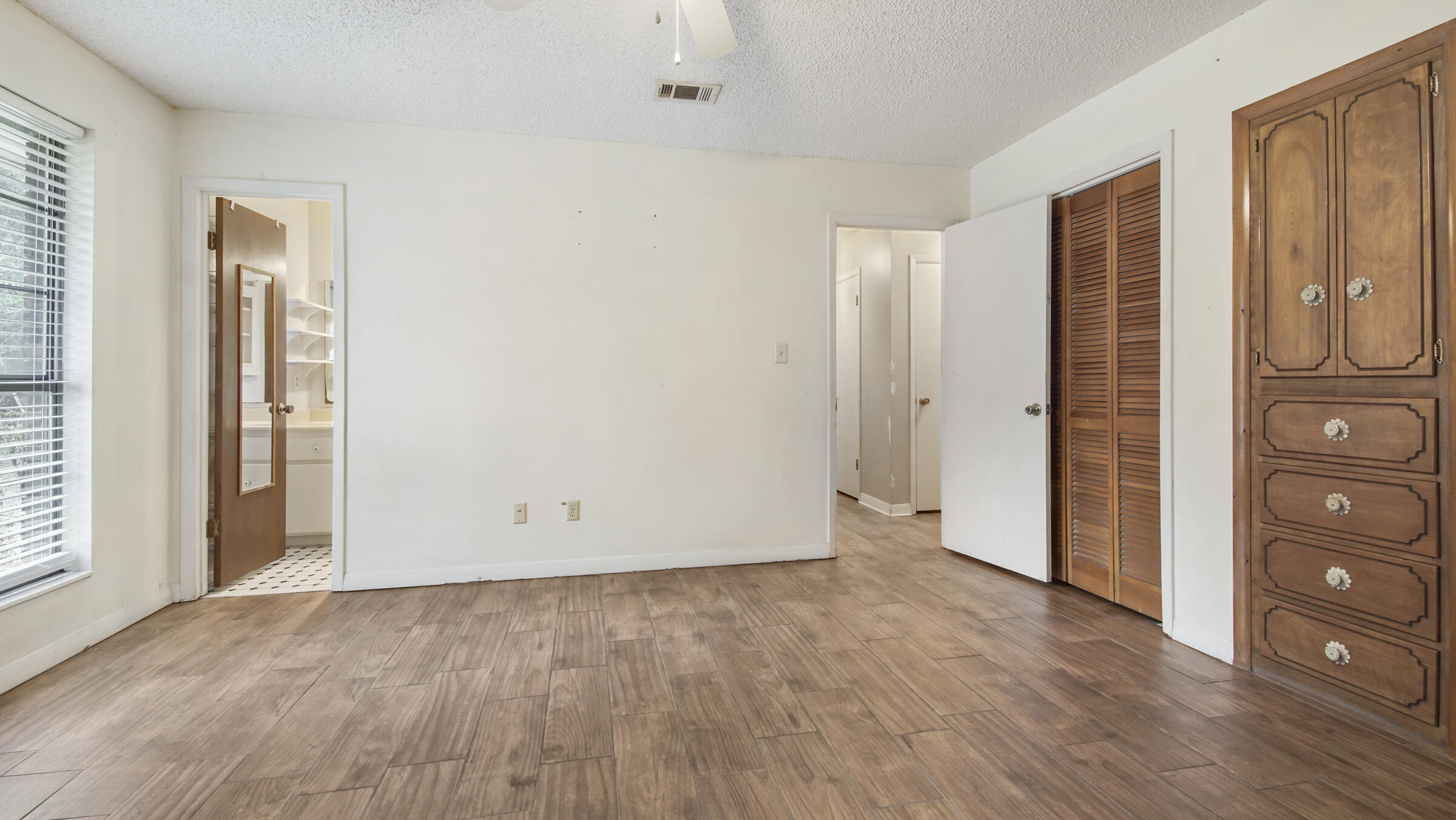5792 Wildwood Road Crestview, FL 32536 - Photo 14 of 43 an empty room with wooden floor and closet area