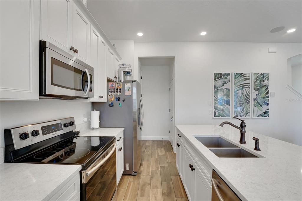 2968 Salted Rim Road Kissimmee, FL 34747 - Photo 9 of 86 a kitchen with stainless steel appliances granite countertop a sink stove and refrigerator