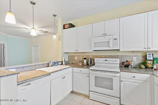a kitchen with white cabinets and white appliances