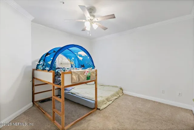 an empty room with ceiling fan and window