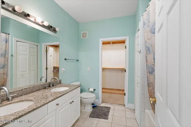 a bathroom with a granite countertop sink a toilet and a shower