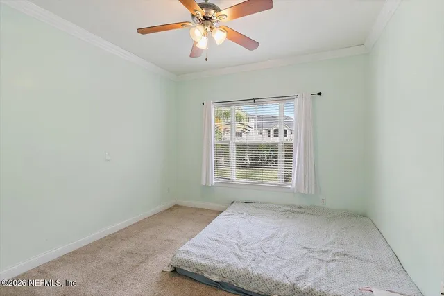 an empty room with a window and a fan