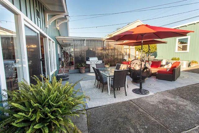 a view of a patio with a dining table and chairs under an umbrella